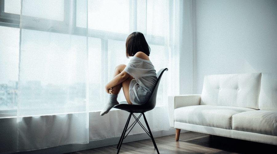 A woman sits silently on a chair
